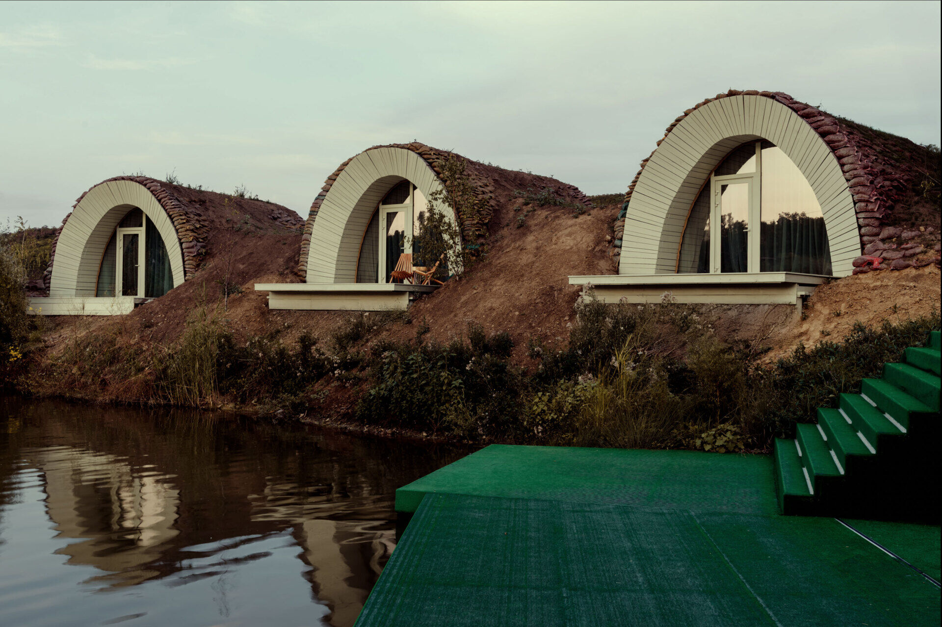 Hobbit-inspired cabins built-into the earth, includes a bedroom, kitchen, and bathroom.