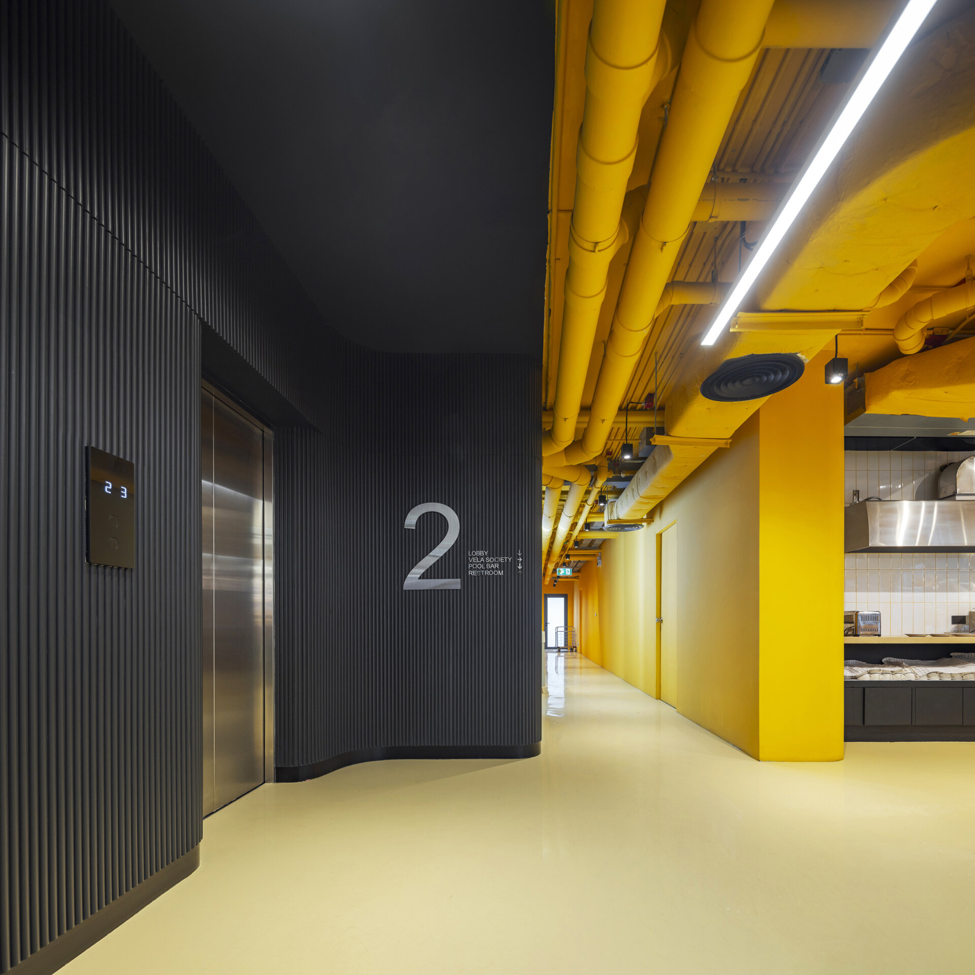 Color-coded hallways guide guests through each floor, with bold hues at the lifts fading into calming tones as you approach the restful hotel rooms.