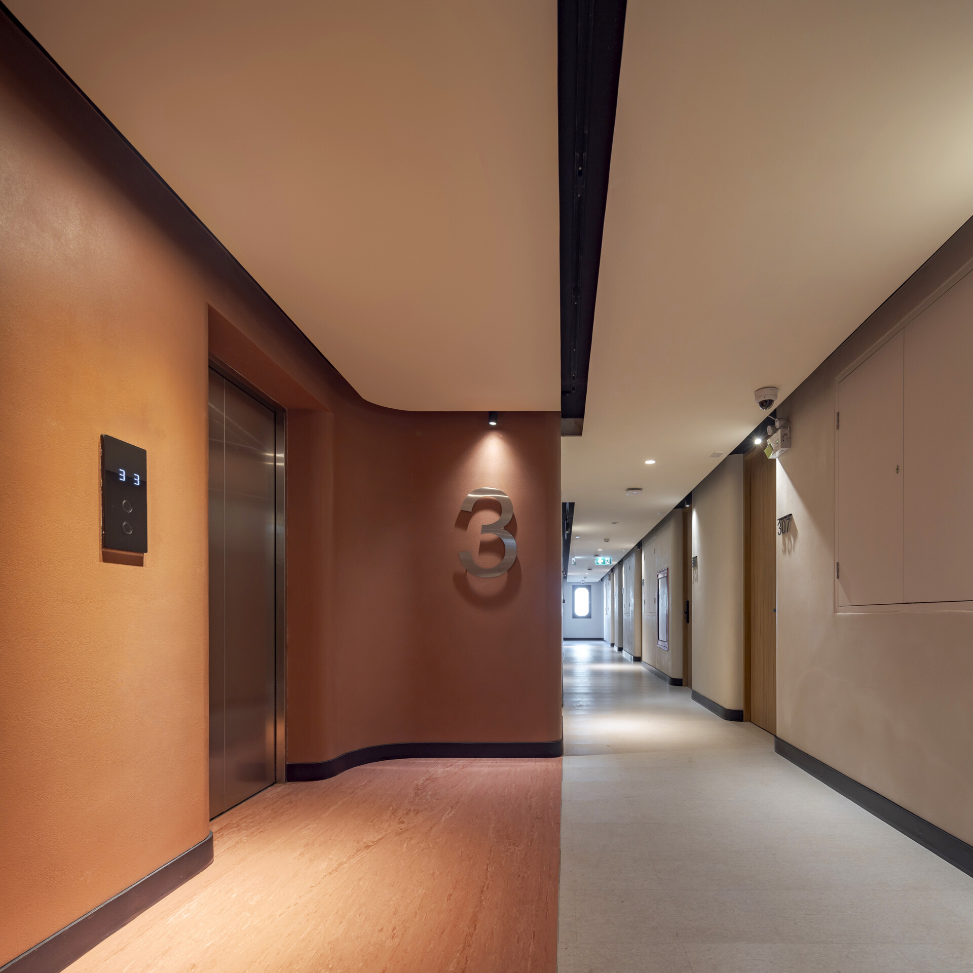Color-coded hallways guide guests through each floor, with bold hues at the lifts fading into calming tones as you approach the restful hotel rooms.