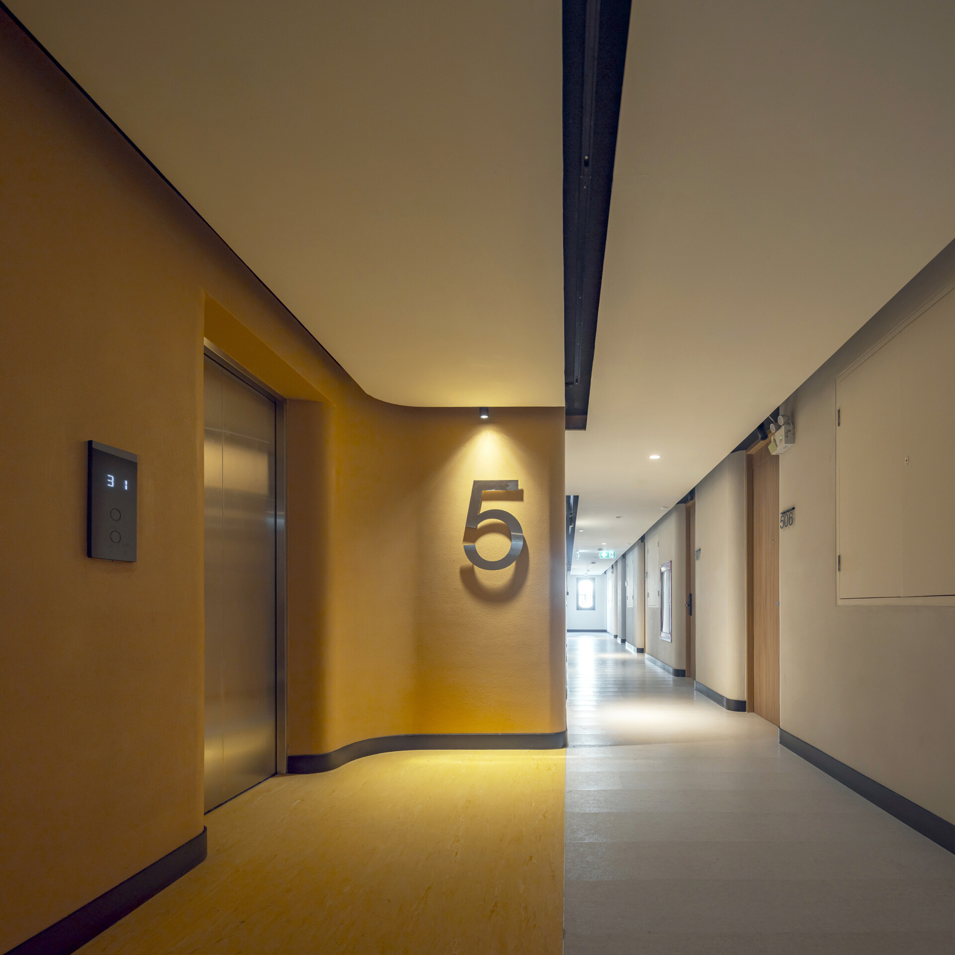 Color-coded hallways guide guests through each floor, with bold hues at the lifts fading into calming tones as you approach the restful hotel rooms.