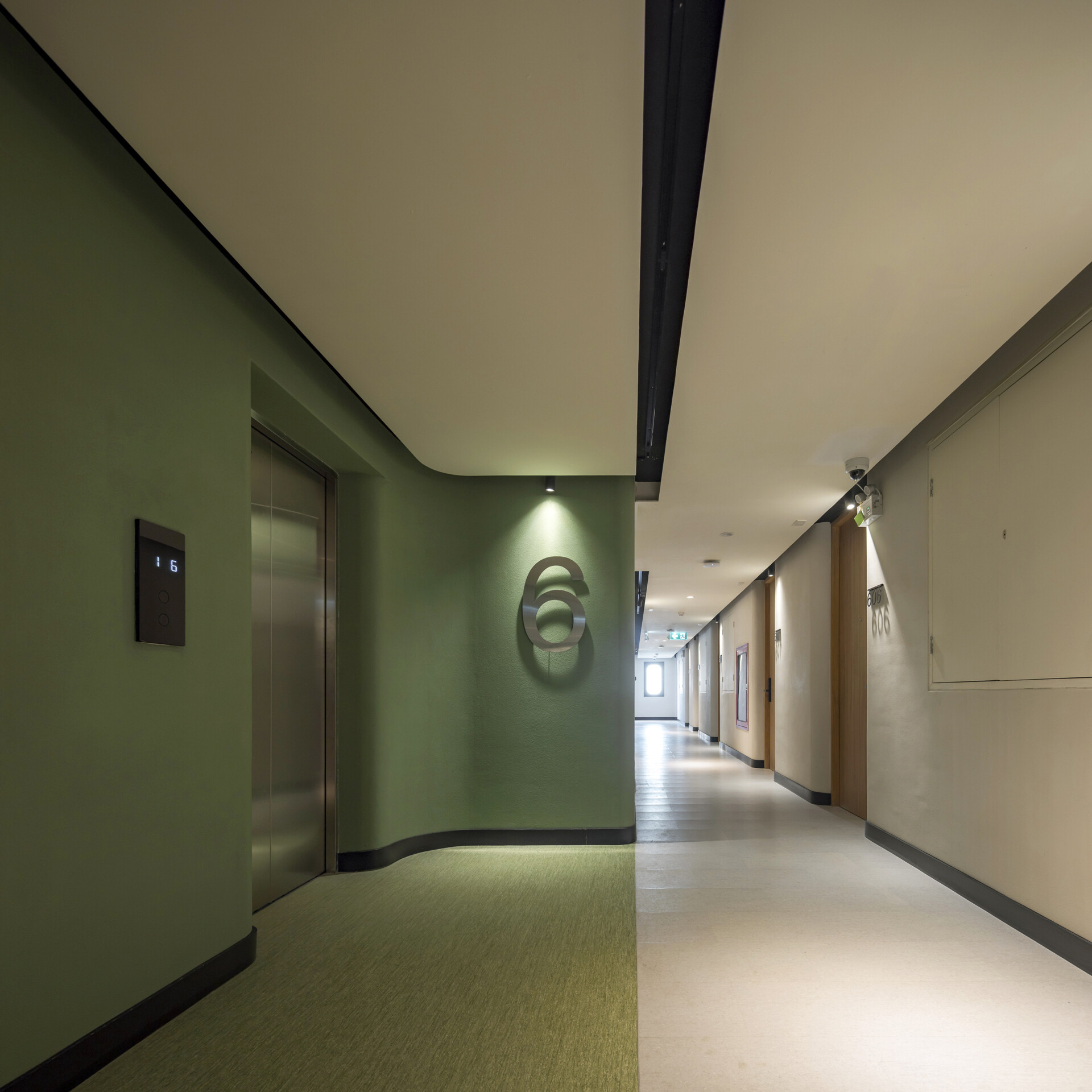 Color-coded hallways guide guests through each floor, with bold hues at the lifts fading into calming tones as you approach the restful hotel rooms.