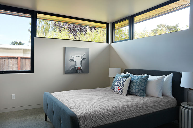 In this bedroom, windows follow the roofline, drawing light deep into the space.