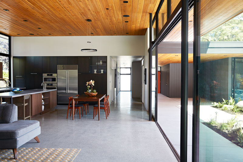 Inside this home, a wall of glass dissolves the boundary between house and garden. The open floor plan brings the kitchen, dining, and living room together in one expansive space filled with natural light. 