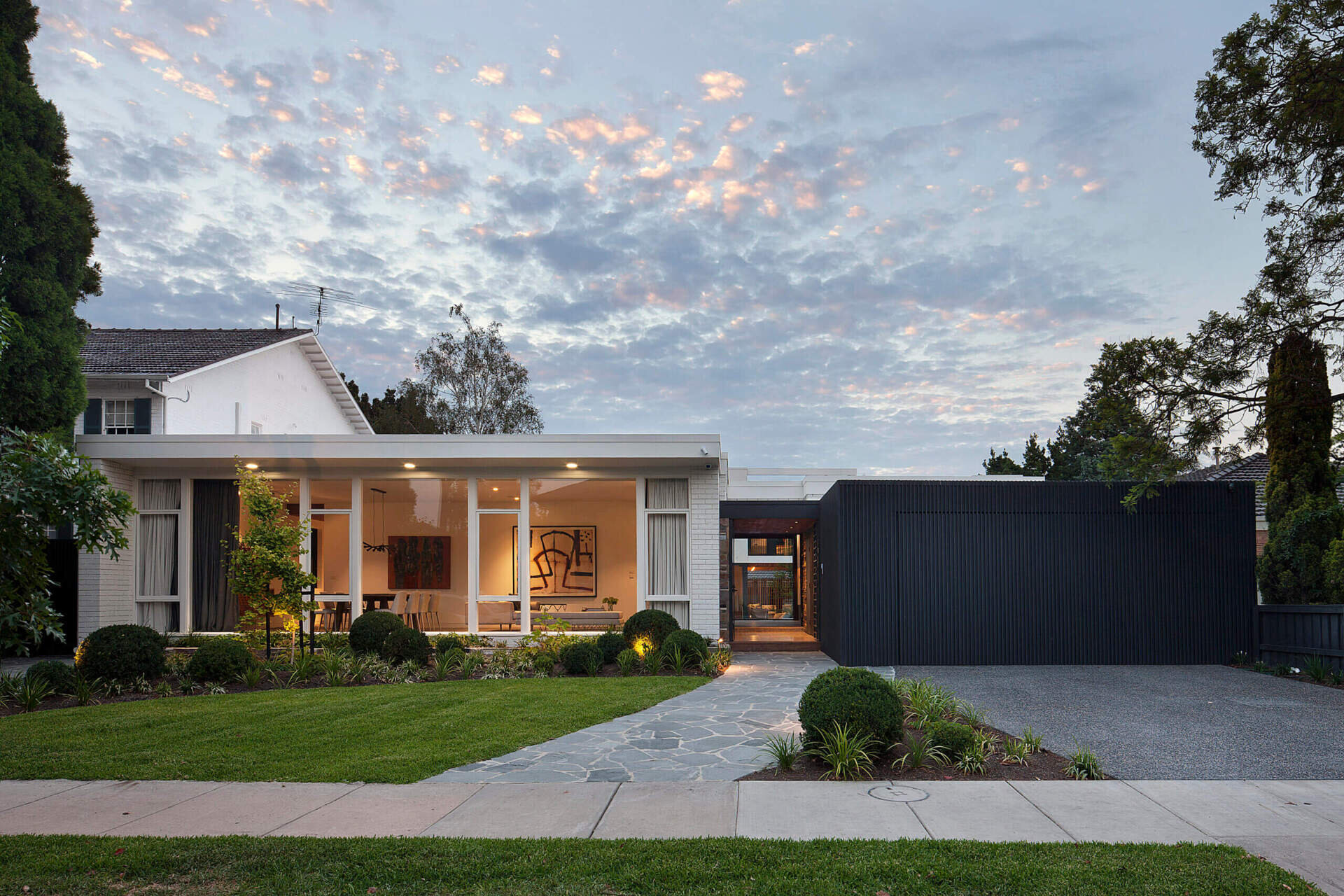 A modern home with a 1960s facade that conceals a bright, contemporary renovation filled with natural light and lush garden views.