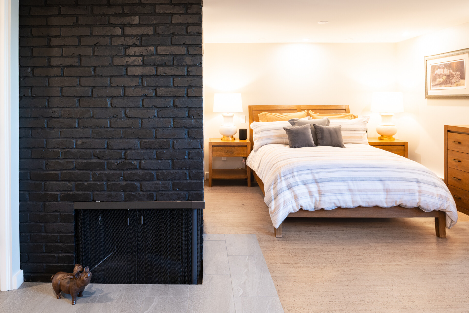 This bedroom is designed as a peaceful getaway, made to feel expansive through the addition of new openings and natural light, while an original fireplace received a painted update.