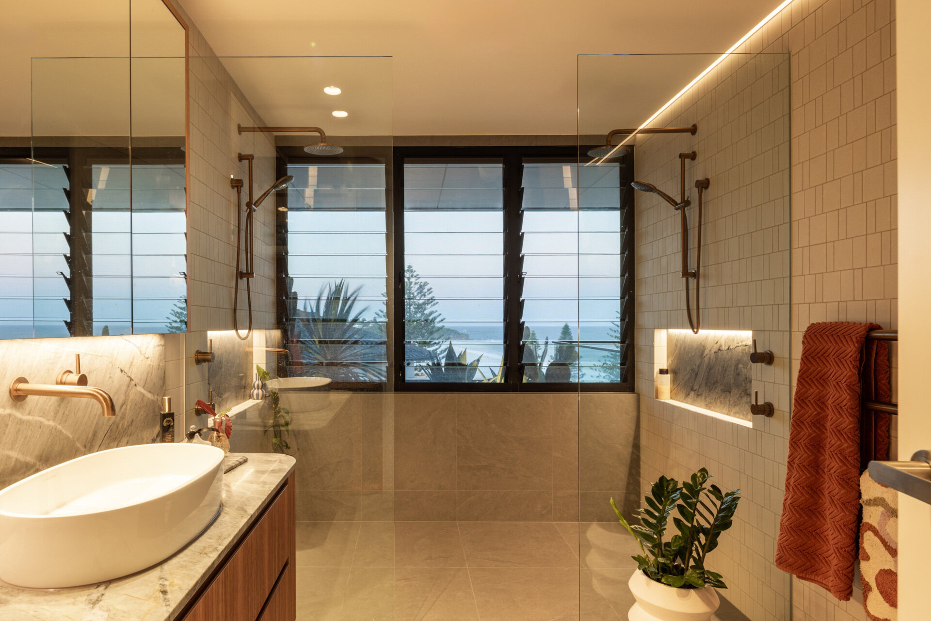 This modern bathroom is designed to feel calm and grounded, a continuation of the home’s restrained materials palette. Natural light filters in to soften stone and timber finishes, elevating the everyday with subtle touches of luxury.