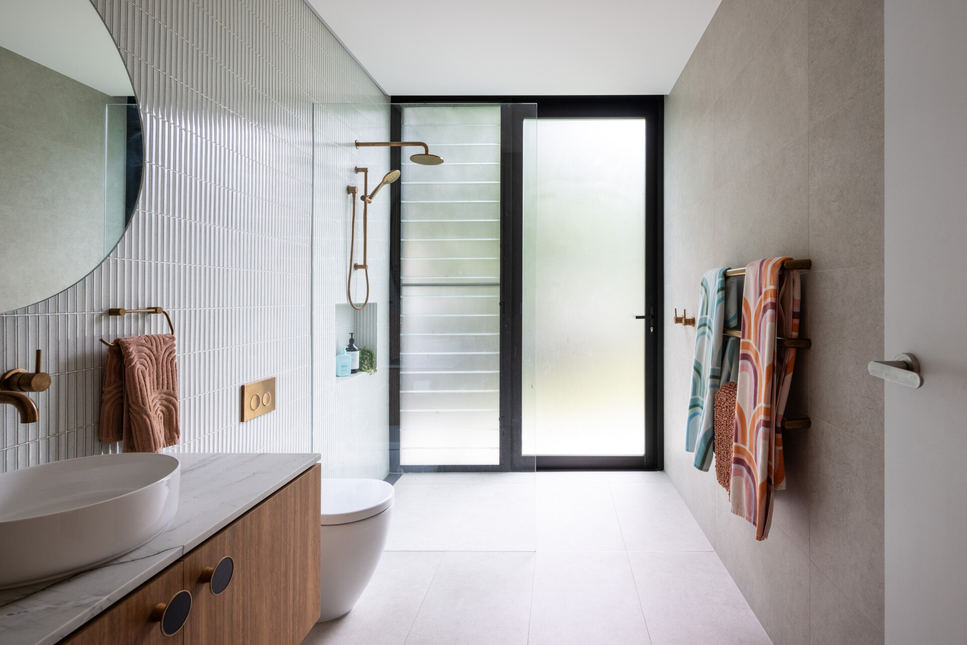 This modern bathroom is designed to feel calm and grounded, a continuation of the home’s restrained materials palette. Natural light filters in to soften stone and timber finishes, elevating the everyday with subtle touches of luxury.