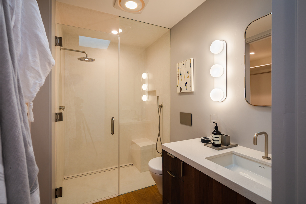 This bathroom mirrors the clean, modern lines of the rest of the home, with a glass shower screen and simple vanity.