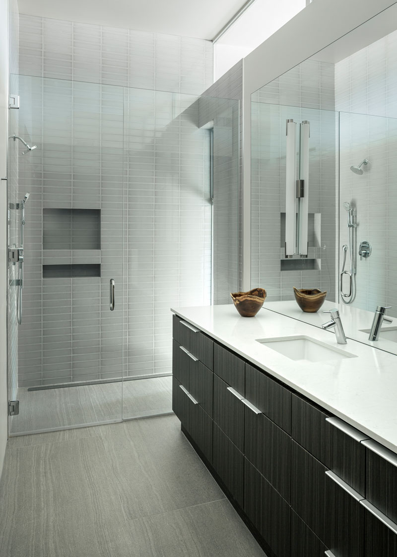 A modern bathroom with a tile-clad shower with shelving niches.