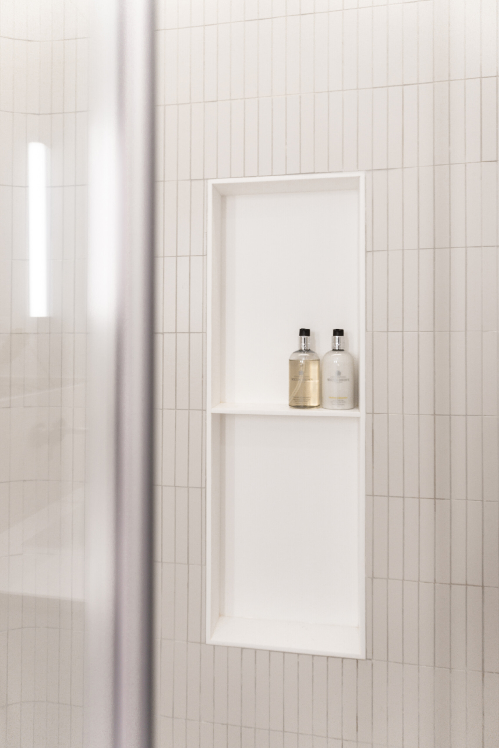 In this bathroom, curves take the lead. Soft-toned materials and indirect lighting work together to highlight the gently rounded walls. A large mirror extends the space visually, while subtle finishes keep the focus on comfort.
