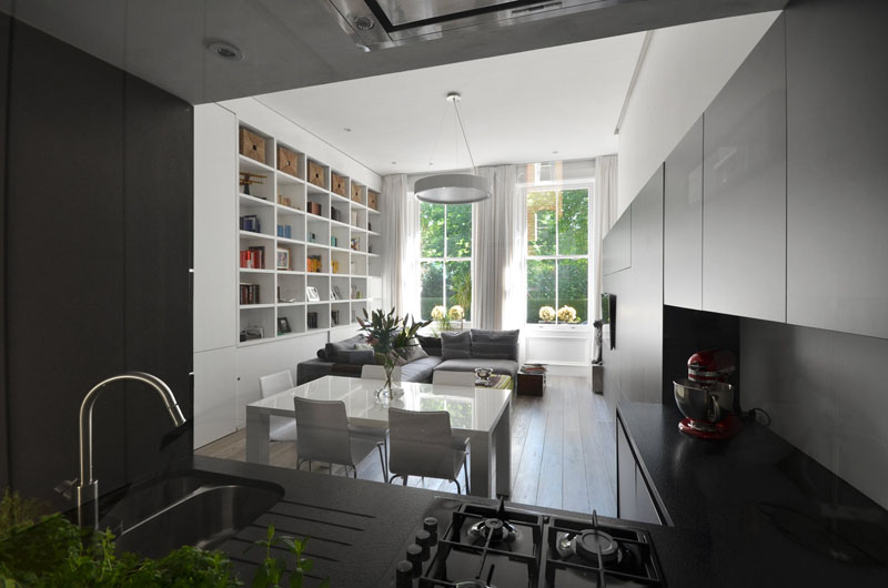 Clever space-saving design turns the kitchen cabinetry into an entertainment center in this stylish London home.