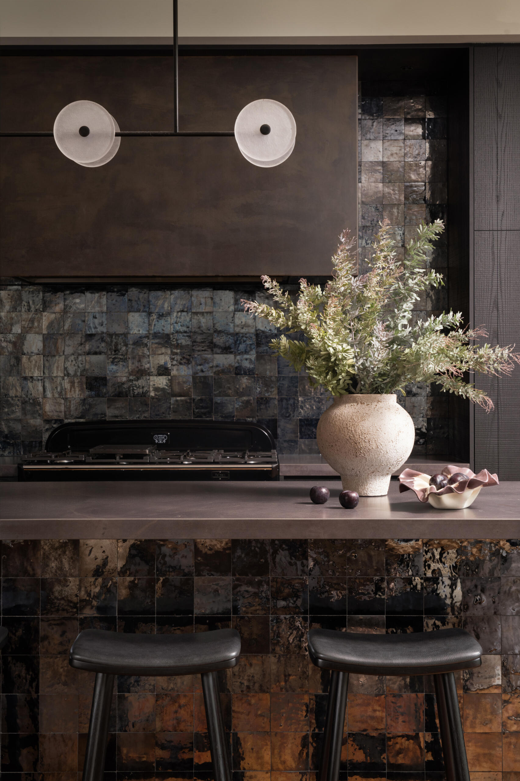 A moody, textured kitchen with custom timber joinery, handmade tiles, and a statement island, paired with a discreet butler’s pantry for effortless entertaining.
