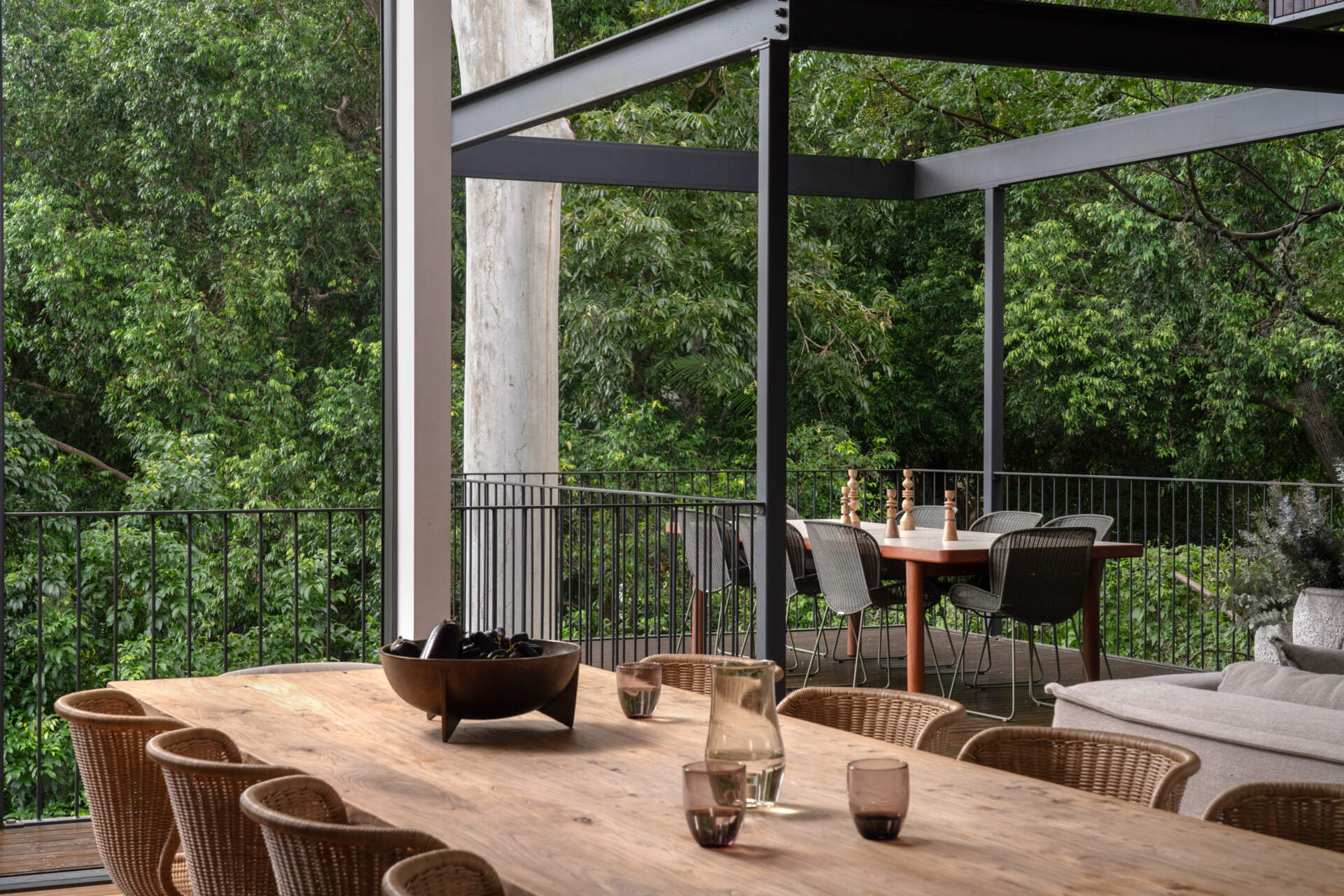 Positioned to enjoy views of the leafy backdrop, the dining area continues the French farmhouse influence with a focus on handmade details. Its connection to both the kitchen and outdoor spaces makes it a central hub for family life.