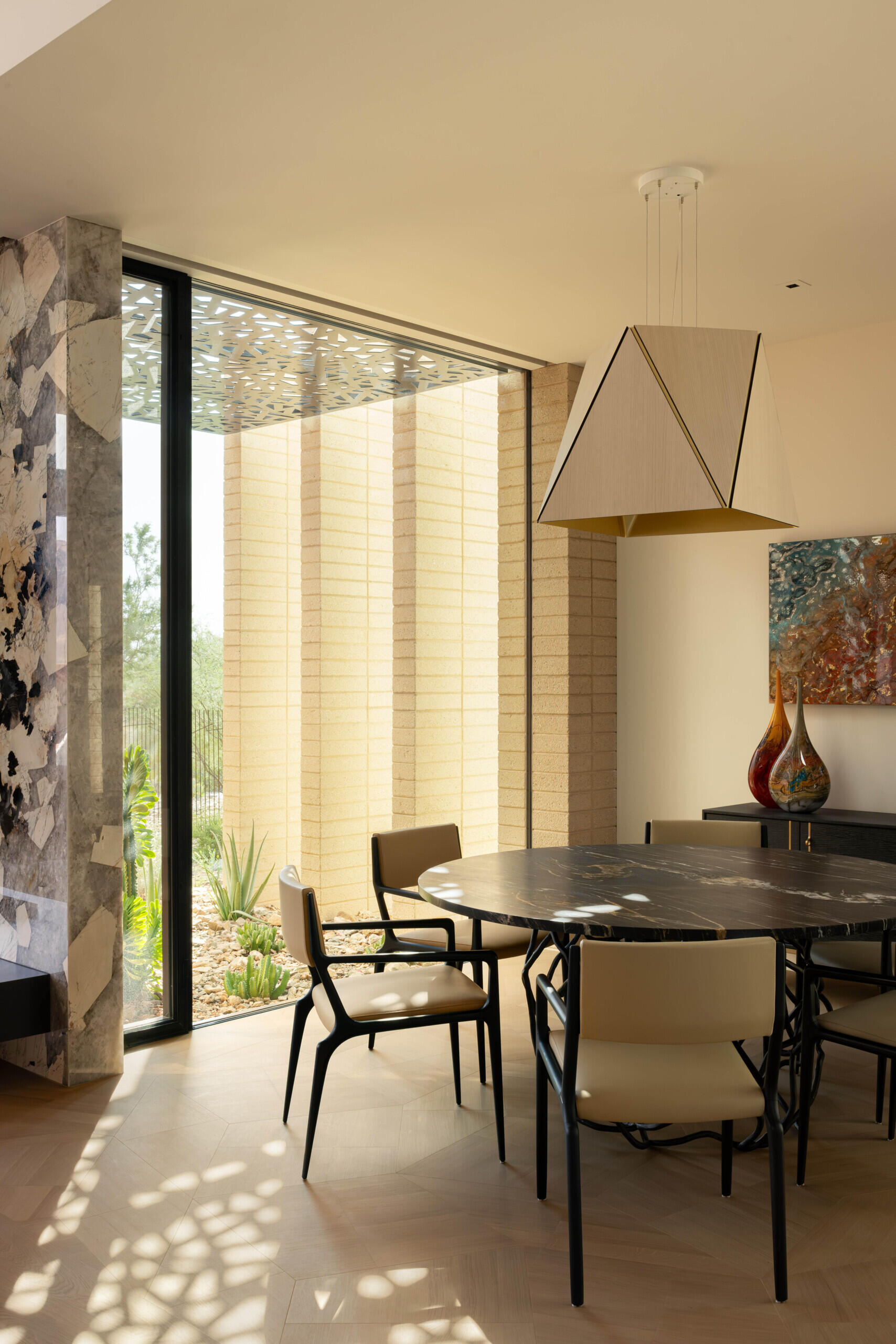 Intimate dining areas are strategically placed to connect with both indoor and outdoor environments. The interplay of light through patterned screens adds texture to mealtime settings.