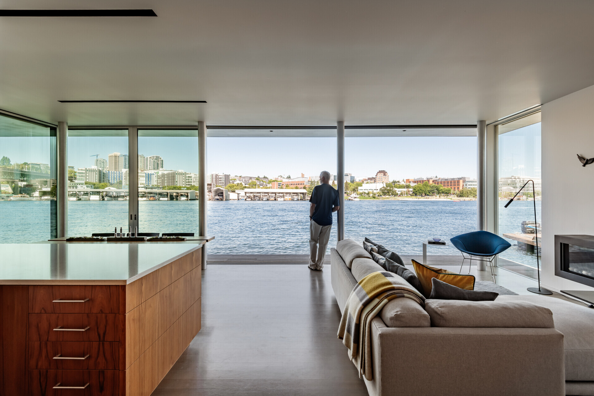 The living area of this float home sits directly on the water’s edge, its glass walls framing uninterrupted lake views. Here, daily life connects seamlessly to the outside world, making the living room a natural gathering place.