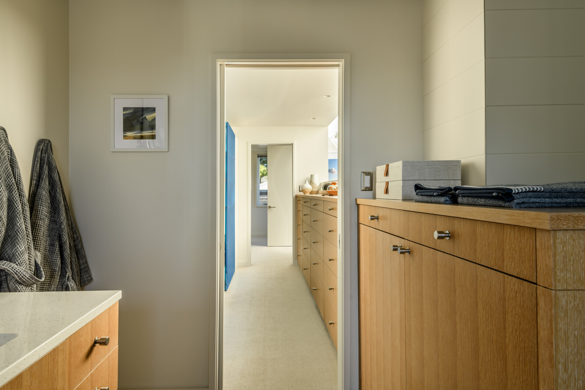 Built-in cabinetry that continues through to the bathroom adds plenty of storage, while a glass-enclosed shower and vanity complete the bathroom.