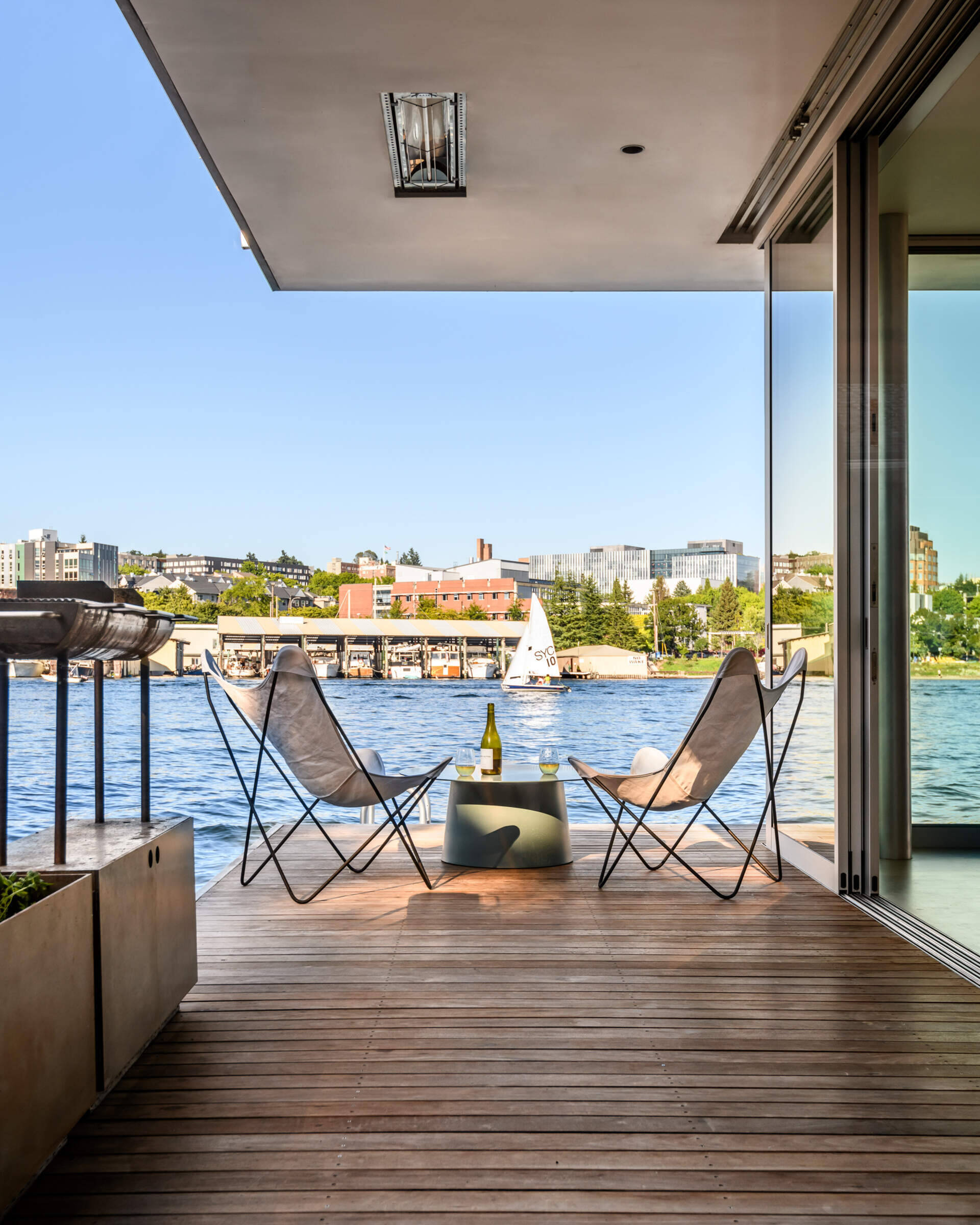 Just beyond the glass walls, a deck extends living to the water. This outdoor platform brings residents even closer to the action of the canal, blurring the line between inside and out.