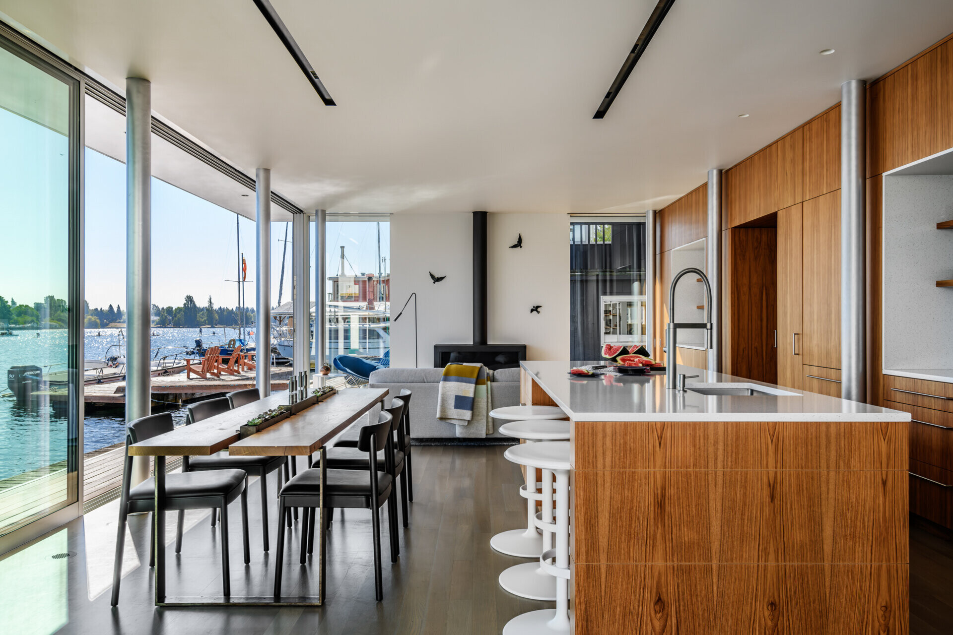 This cabinetry in the living room that lines the wall transitions to become the kitchen cabinets, while the dining area sits seamlessly between the kitchen island and the deck.