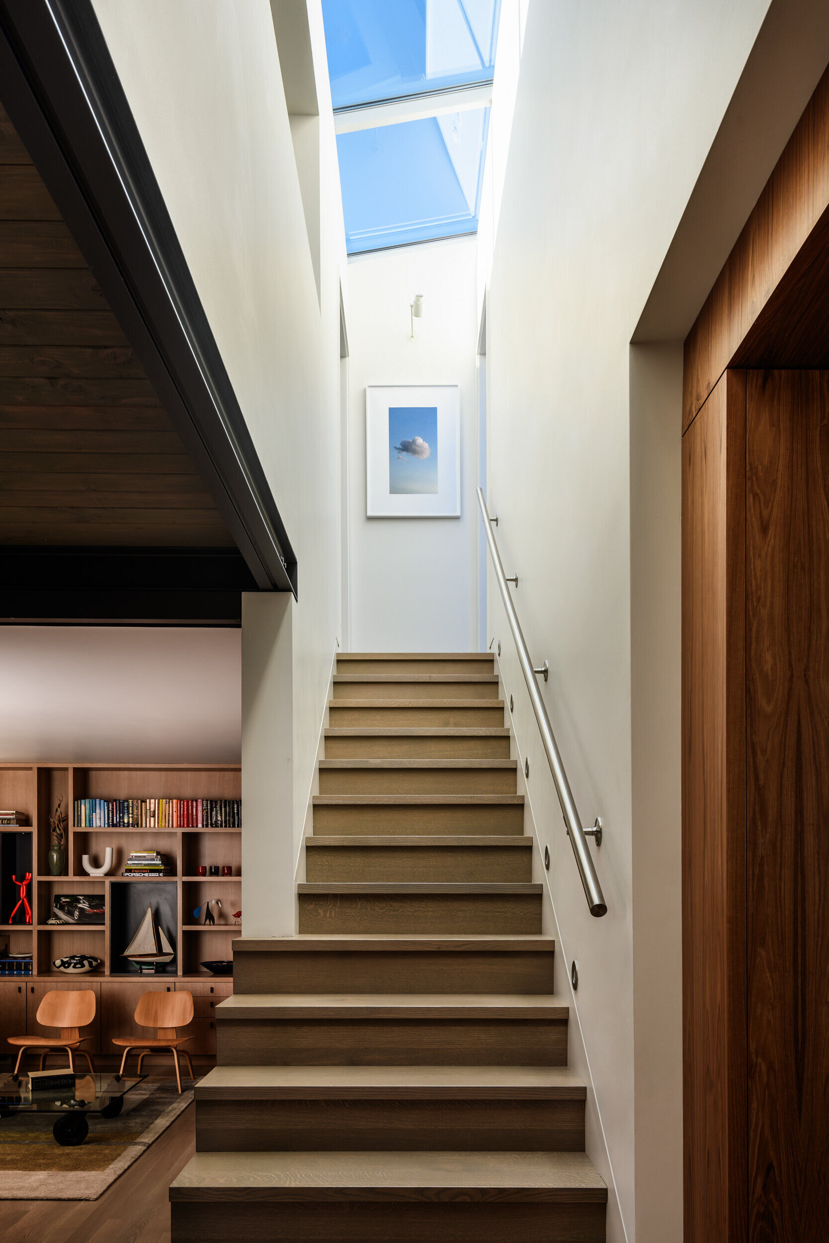 Wood stairs lead upward through this float home, while skylights above fill the interior with natural light and connect the levels with a sense of openness.