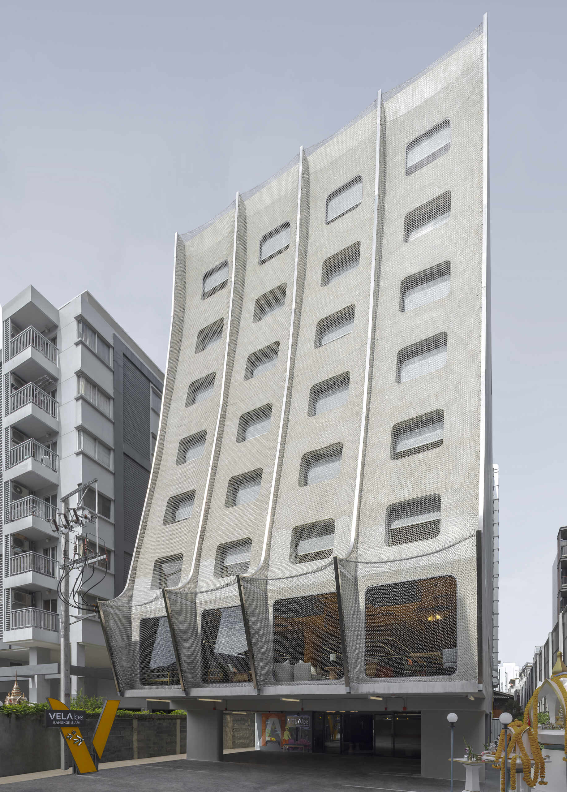 A fresh take on Thai architecture: this Bangkok hotel’s facade blends carved traditional Pun-Lom details with glimmering stainless steel chains, nodding to mosquito nets from the past.