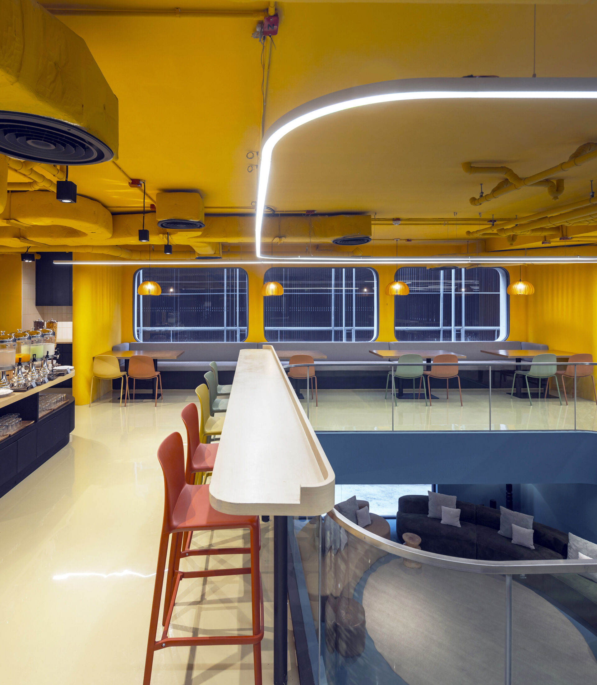 A dynamic social space where bold colors, patterns, and flexible zones encourage guests to eat, work, relax, or play, all in one stylish setting.