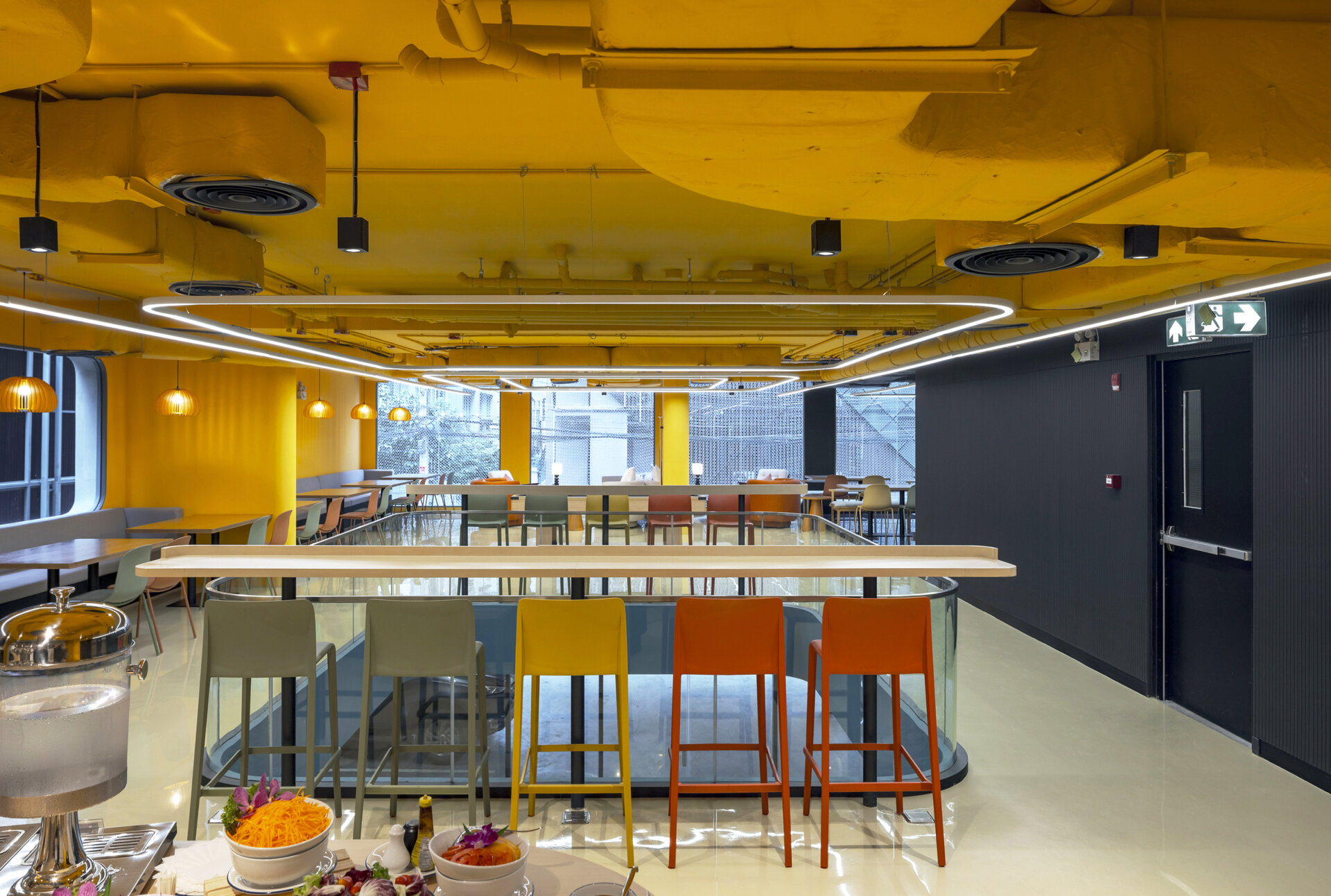 A dynamic social space where bold colors, patterns, and flexible zones encourage guests to eat, work, relax, or play, all in one stylish setting.