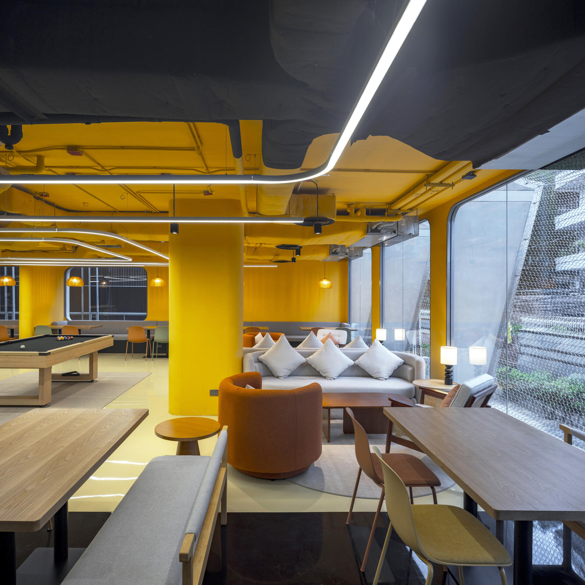 A dynamic social space where bold colors, patterns, and flexible zones encourage guests to eat, work, relax, or play, all in one stylish setting.
