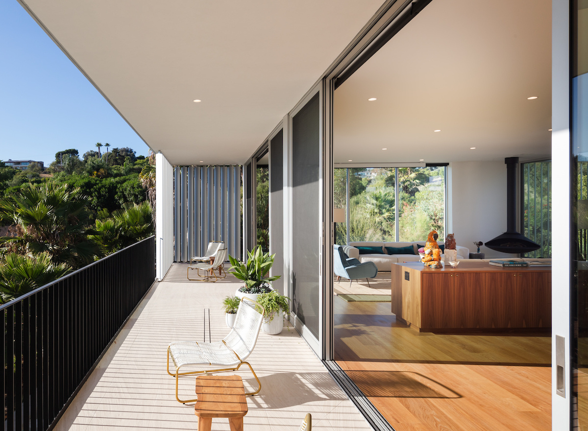 Adjacent to the living room, the dining area features an oval dining table, while nearby sliding doors open to a balcony. Elevated views enhance the sense of openness, making this area of the home perfect for everyday use and entertaining.