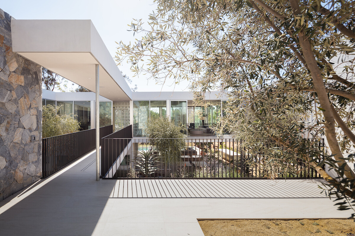 A striking bridge connects to the main social areas of the home, reinforcing the theme of floating architecture and highlighting the engineering precision behind the project.
