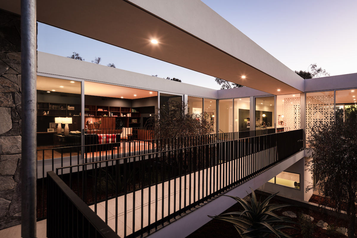A striking bridge connects to the main social areas of the home, reinforcing the theme of floating architecture and highlighting the engineering precision behind the project.