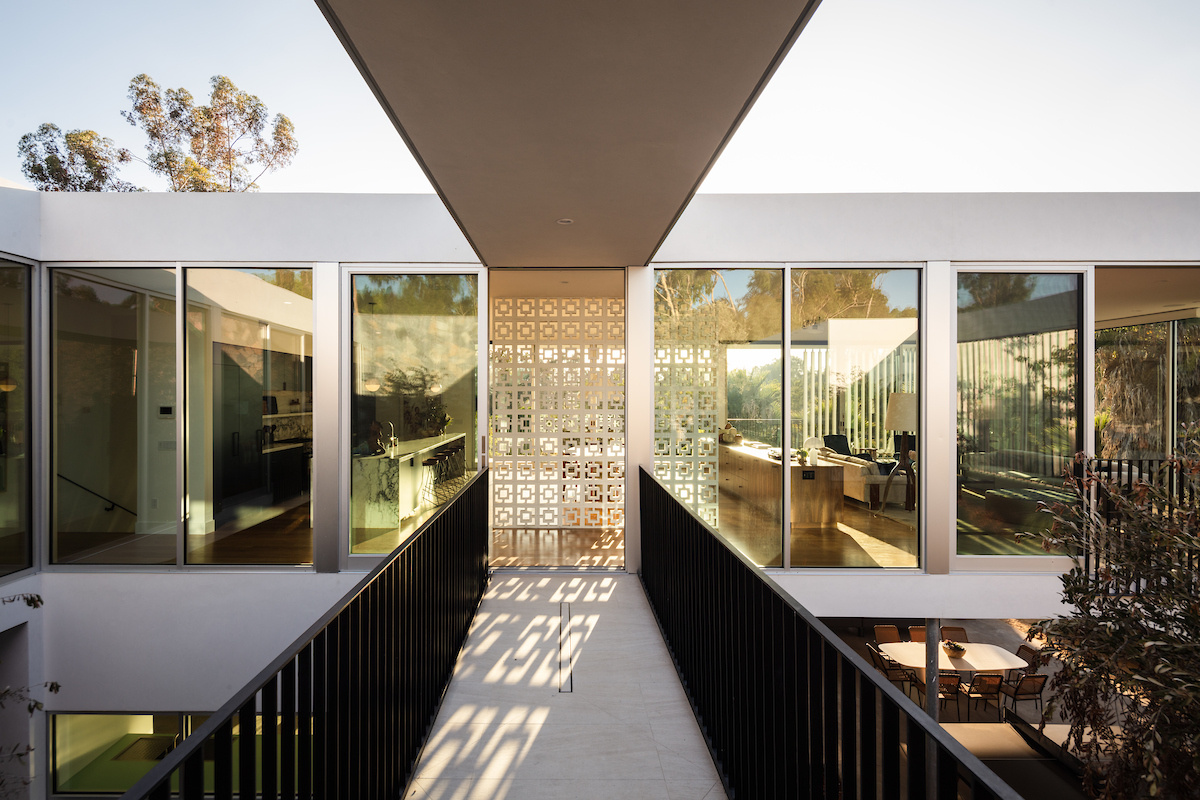 A striking bridge connects to the main social areas of the home, reinforcing the theme of floating architecture and highlighting the engineering precision behind the project.