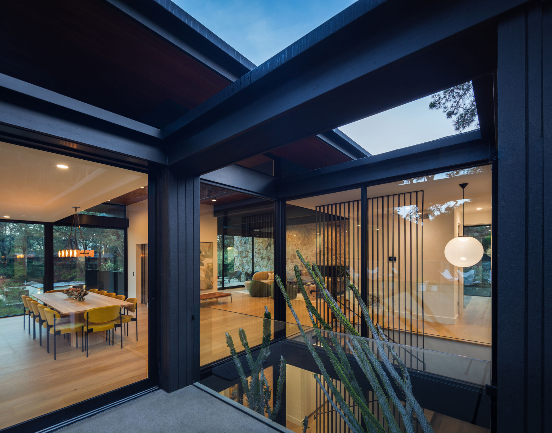 Retractable glass walls open wide, erasing any barrier between interior spaces and the surrounding landscape. They provide natural ventilation while reinforcing the home’s indoor-outdoor lifestyle.