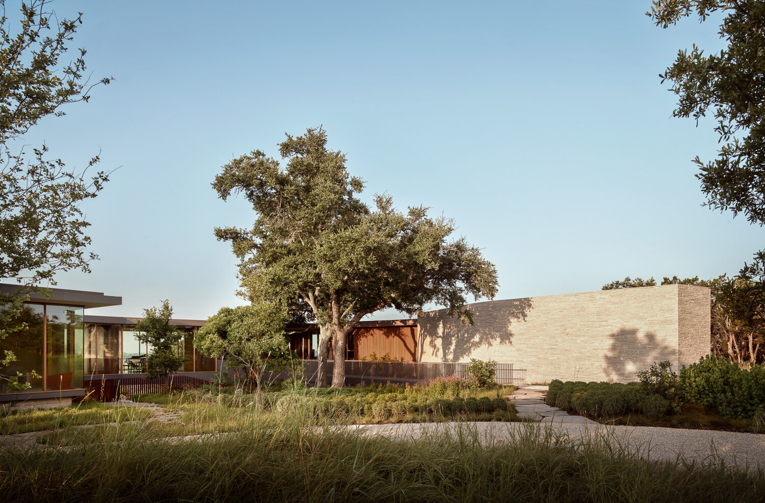 A cinematic entry bridge skirts oak trees and reveals glimpses of what lies beyond.