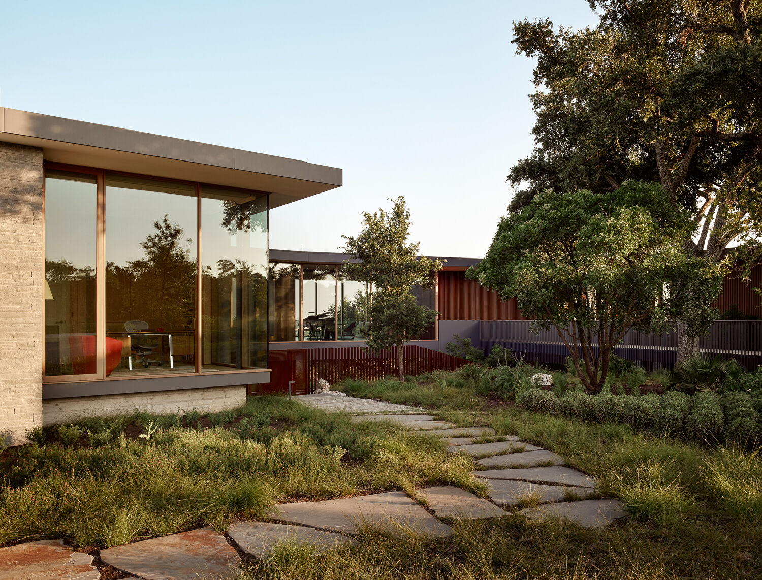 A cinematic entry bridge skirts oak trees and reveals glimpses of what lies beyond.