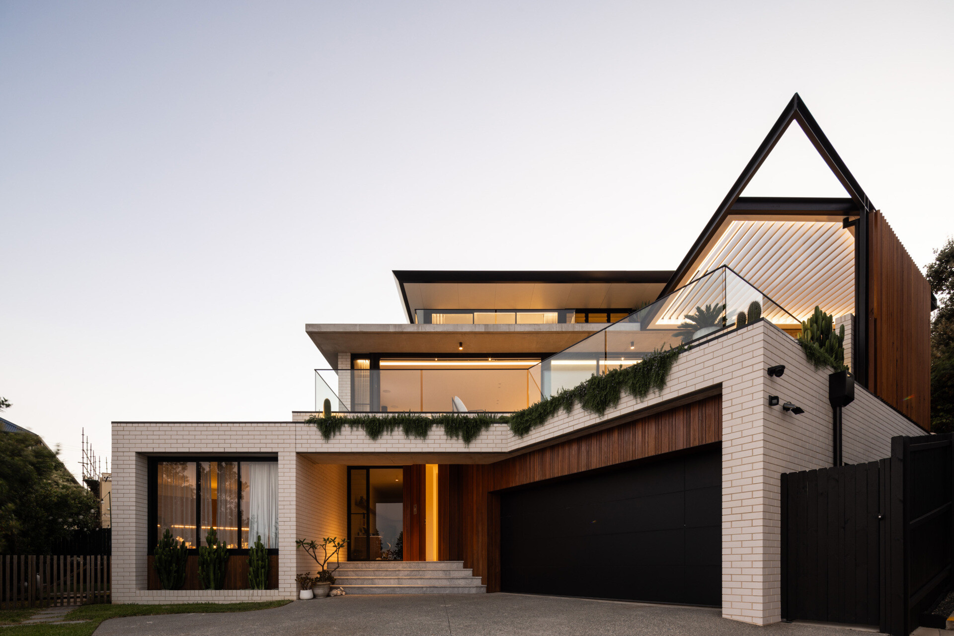 Arrival to this modern home is via a lower-level entry that also houses a garage and generous utility and storage zones, practical and discreetly integrated into the base of the structure. From here, the home unfolds upward, revealing more of the view and more of its carefully layered design.