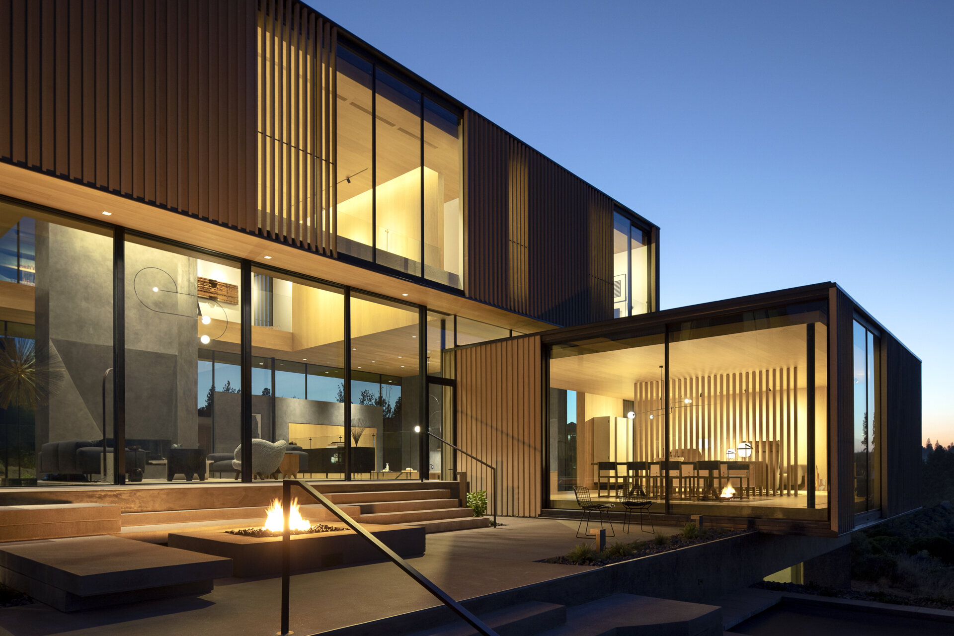 This modern home is designed as a series of cascading platforms that step down a pumice-covered hillside. Inspired by nearby volcanic rock formations, faceted mass walls anchor the structure, guiding movement and framing both intimate and expansive views. 