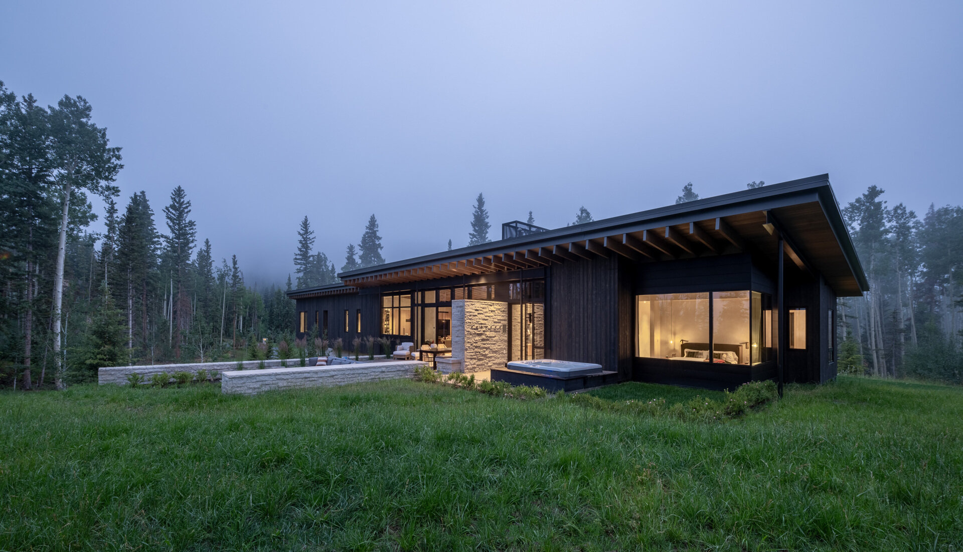Rough sawn cedar, limestone, and steel ground this modern home in its wooded setting.
