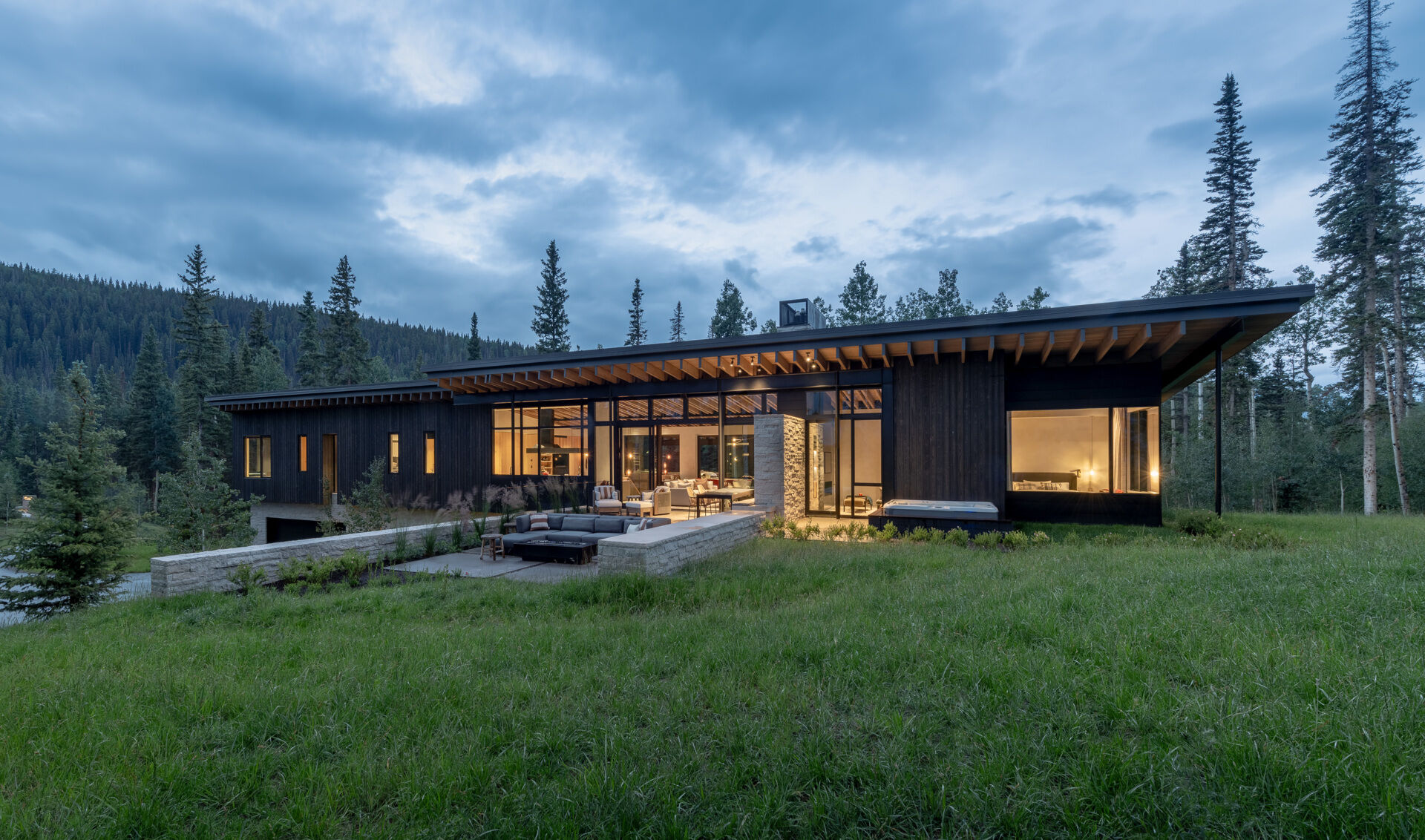 Rough sawn cedar, limestone, and steel ground this modern home in its wooded setting.