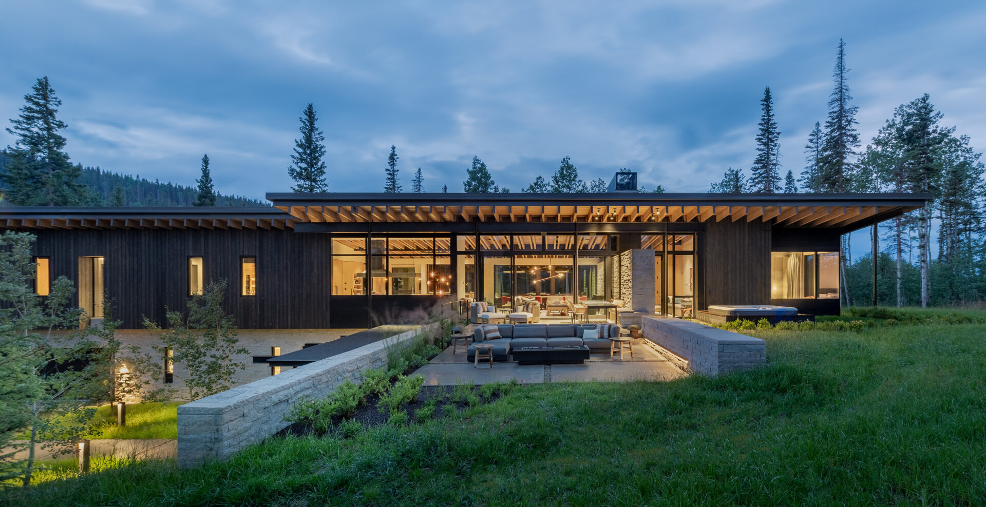 Rough sawn cedar, limestone, and steel ground this modern home in its wooded setting.