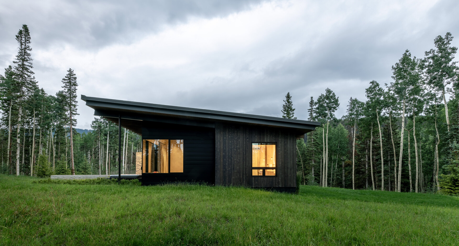 Rough sawn cedar, limestone, and steel ground this modern home in its wooded setting.