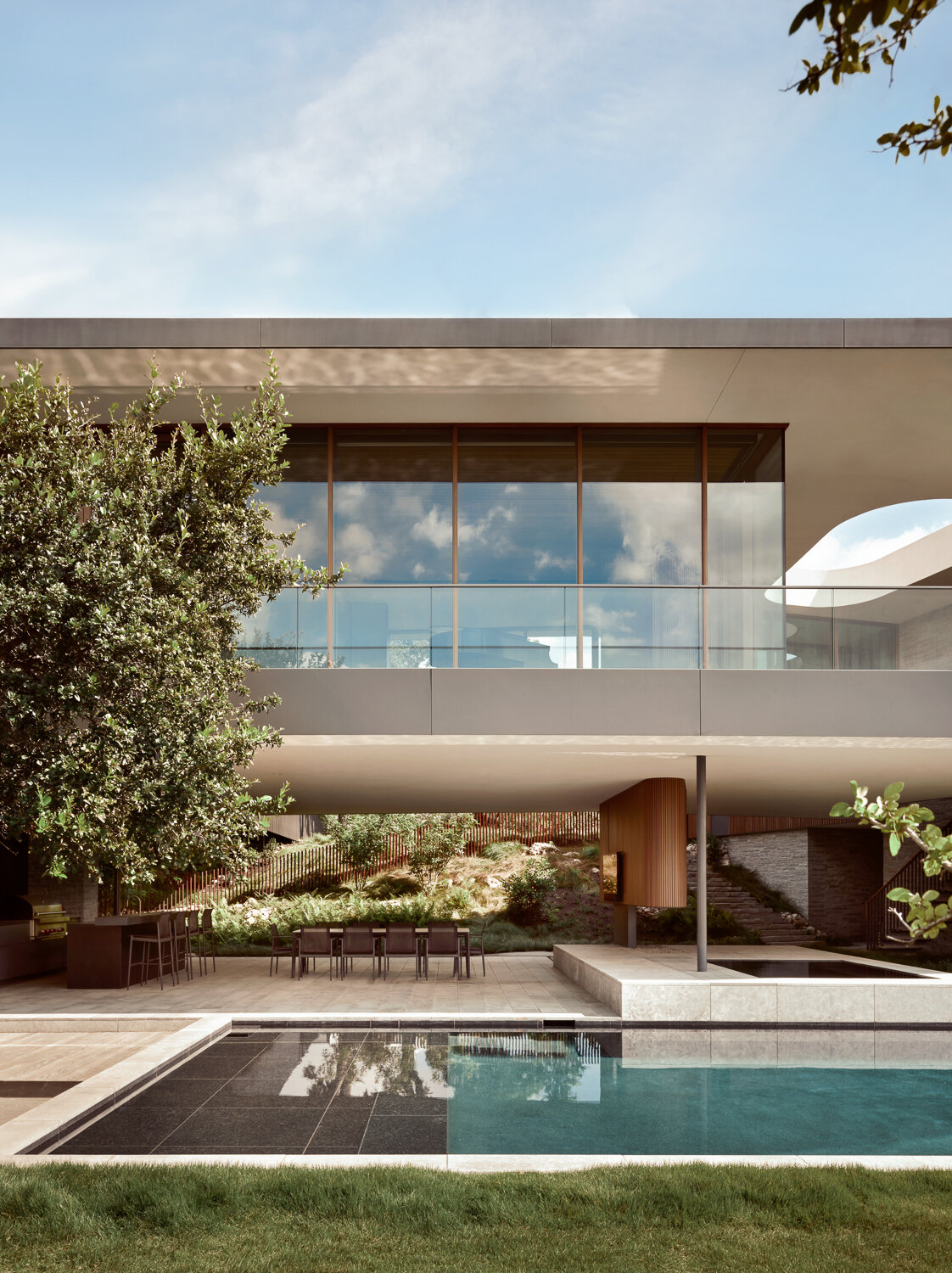 A breezy terrace leads to the pool, lawn, and expansive Austin views.