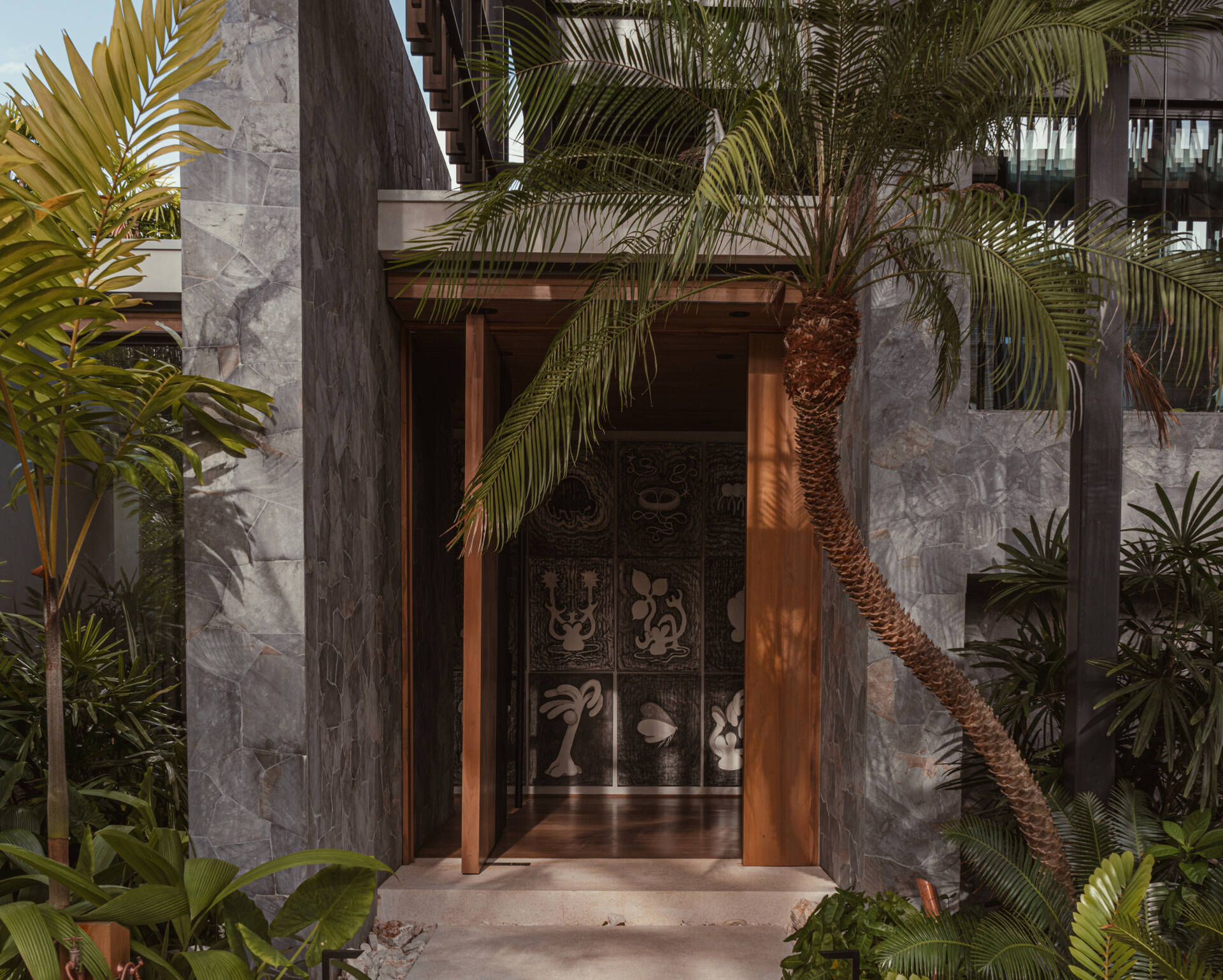 A modern oversized pivoting wood front door.