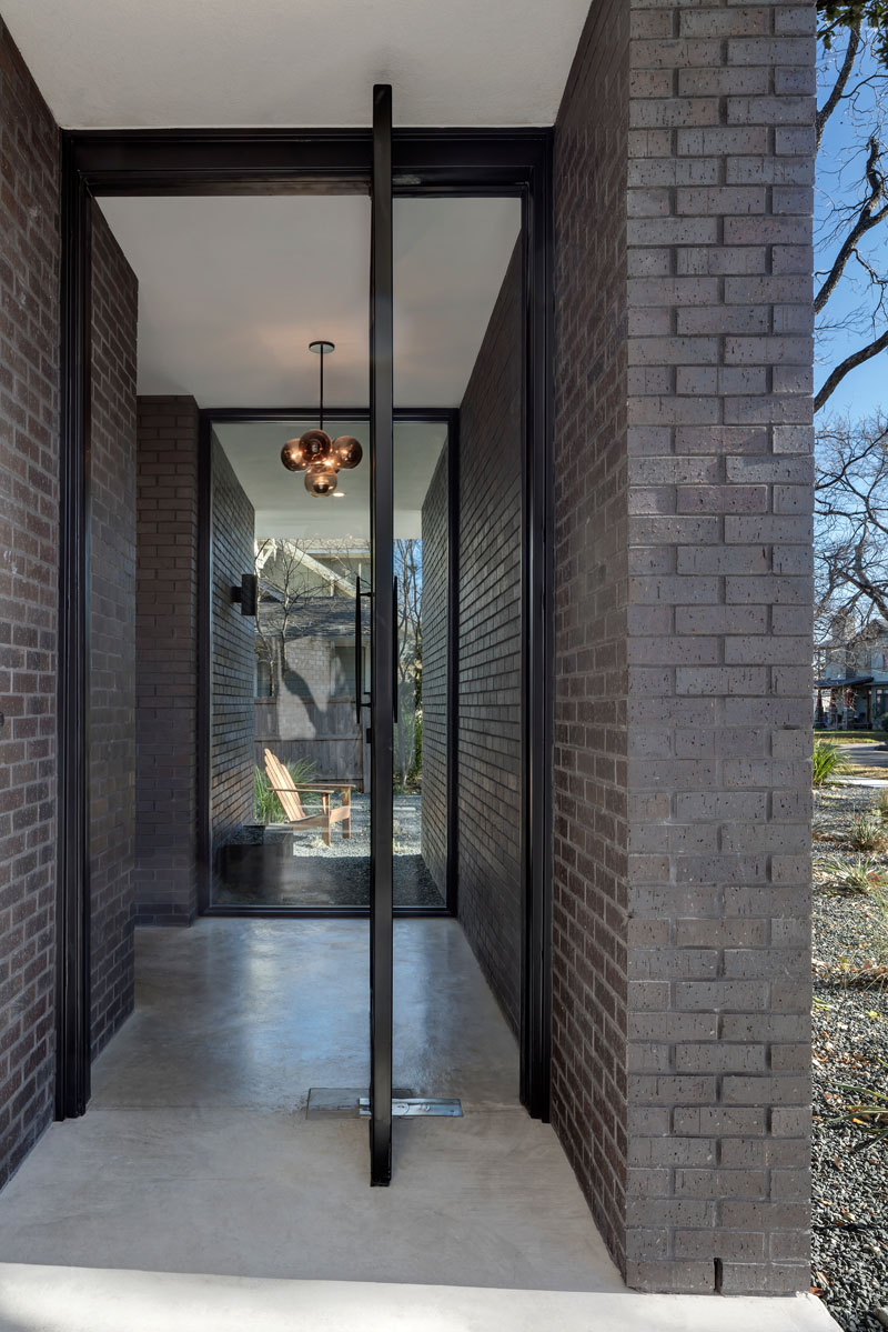 Rather than a straight path, the entry experience is guided by the facade’s layout, leading visitors toward a striking pivoting front door. This indirect approach heightens privacy while making arrival feel intentional and considered.