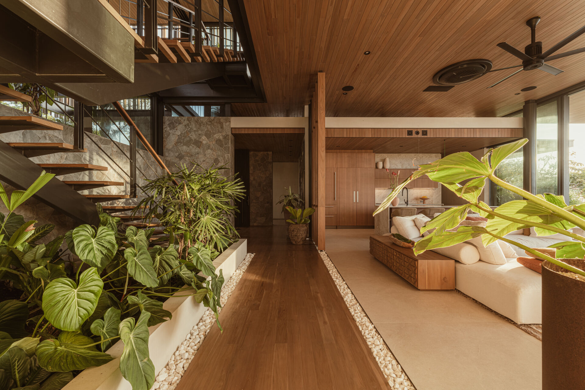 A floating stairwell becomes its own architectural moment. Suspended within a vertical garden, the stairs act as a quiet connector between levels while drawing attention to the surrounding vegetation. The stair's open design lets light pass through and continues the home’s lightness and spatial rhythm.