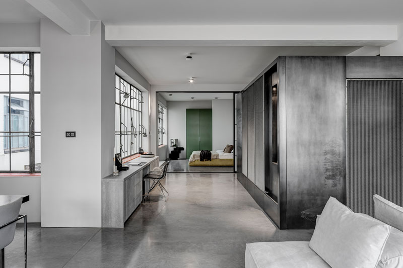 The bedroom carries forward the apartment’s theatrical atmosphere. A custom headboard hides soft integrated lighting, creating a muted glow, while a sliding privacy screen separates the space from the rest of the apartment when needed.