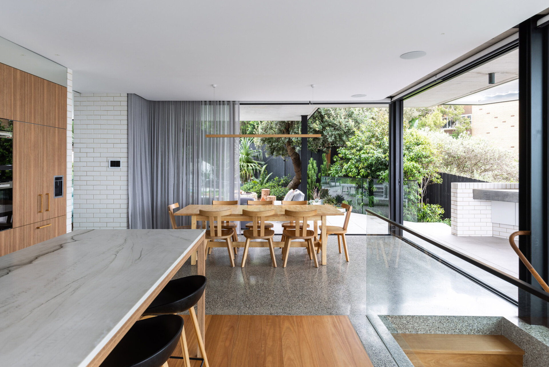 On the main level of this modern home, floor-to-ceiling glazing wraps the open-plan living, dining, and kitchen zone. This level connects directly to both the garden and the beach-facing terrace, blurring indoor and outdoor living. Designed for entertaining and everyday comfort, it’s all about flow, light, and uninterrupted views.