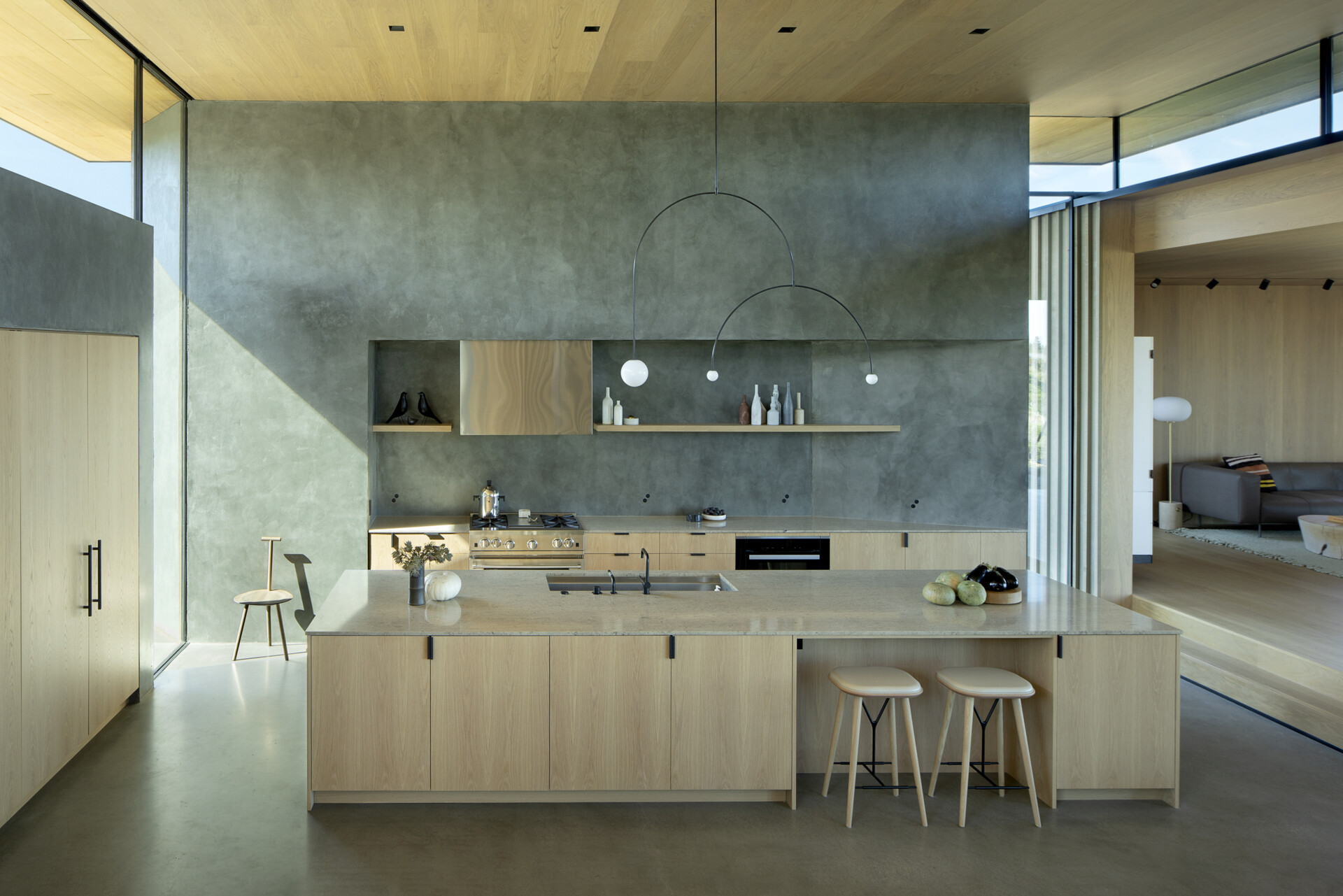 Located on its own platform, the kitchen serves as both a functional hub and a social gathering point. Its open positioning allows it to flow into adjacent living areas while still offering moments of privacy within the home’s sculptural form.