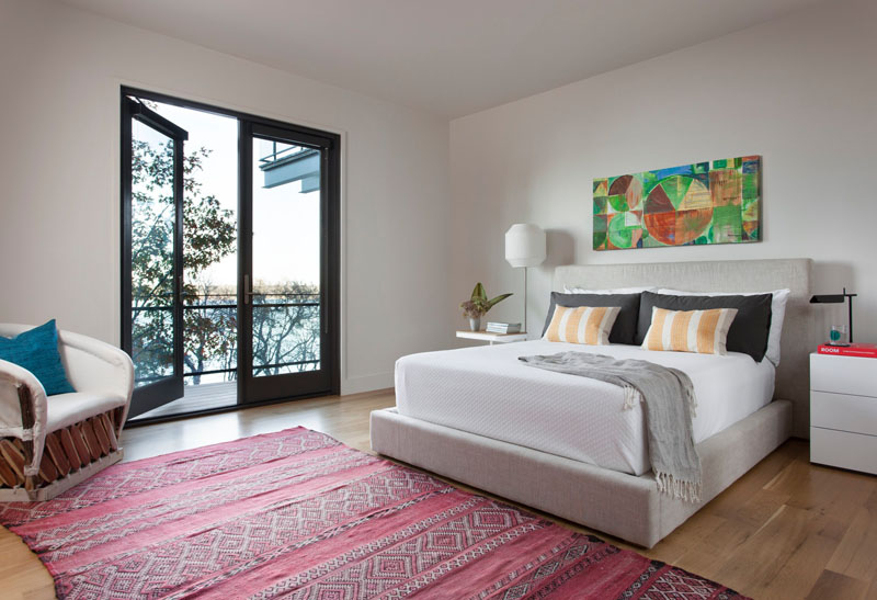 A modern bedroom with a small walk-out balcony.