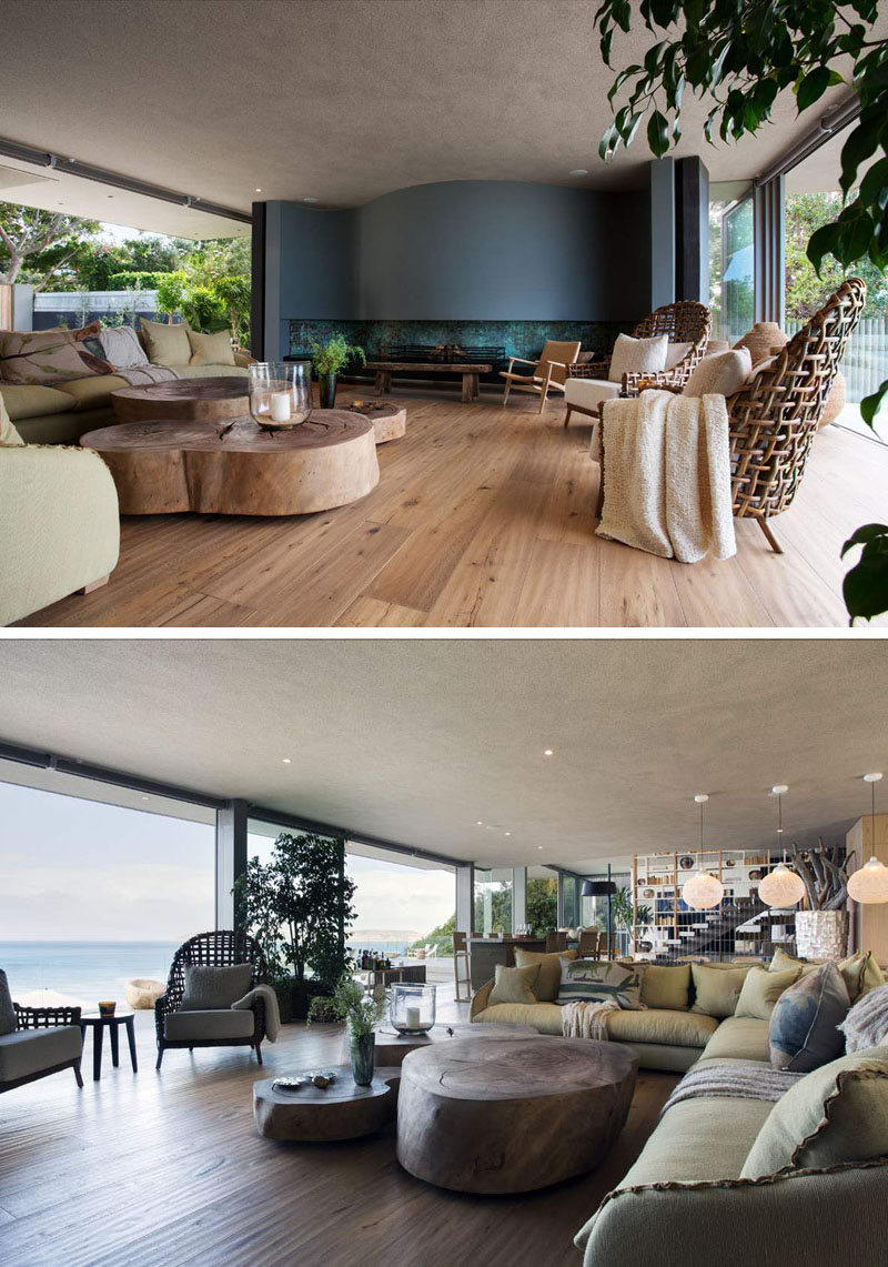 The main living space features a curved fireplace, oversized wood tables, and glass doors opening to the balcony.