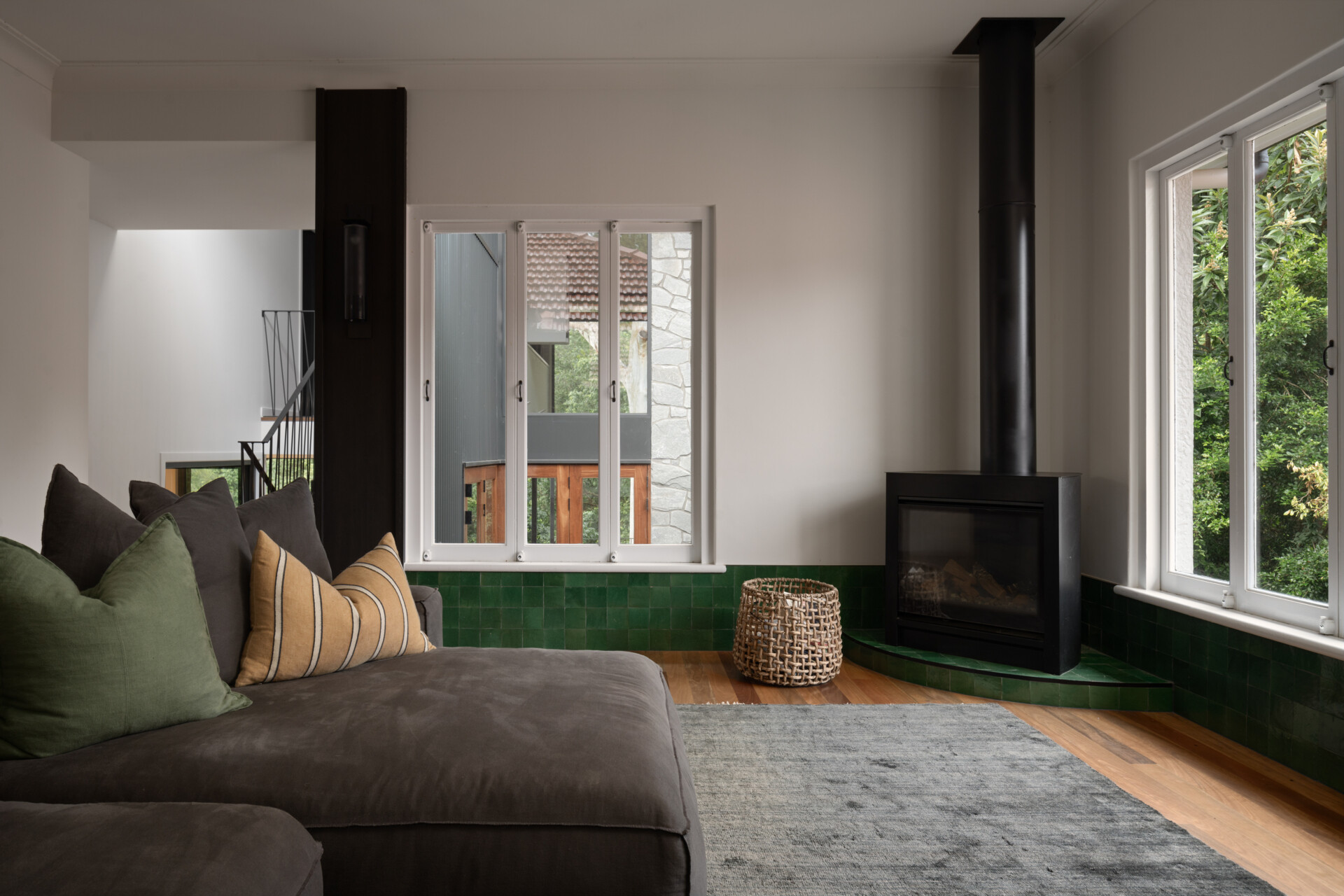 This more intimate living space is defined by handmade green tiles line lower section of the wall, and add color and character. It offers a quieter retreat within the home, balancing the openness of the main living areas.